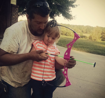 Father and daughter with bow and arrow
